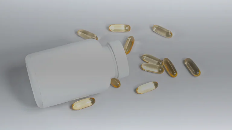 Capsules molles de vitamine D échappées d&rsquo;un flacon blanc