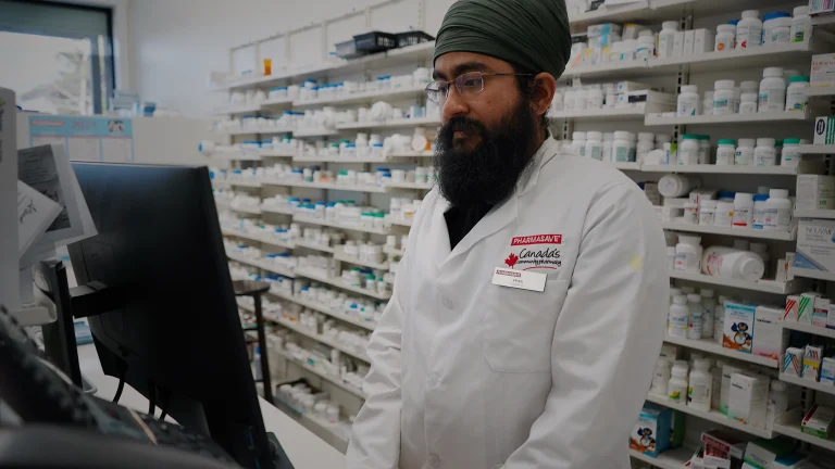 Professionnel au comptoir d’une pharmacie, photographie d’illustration